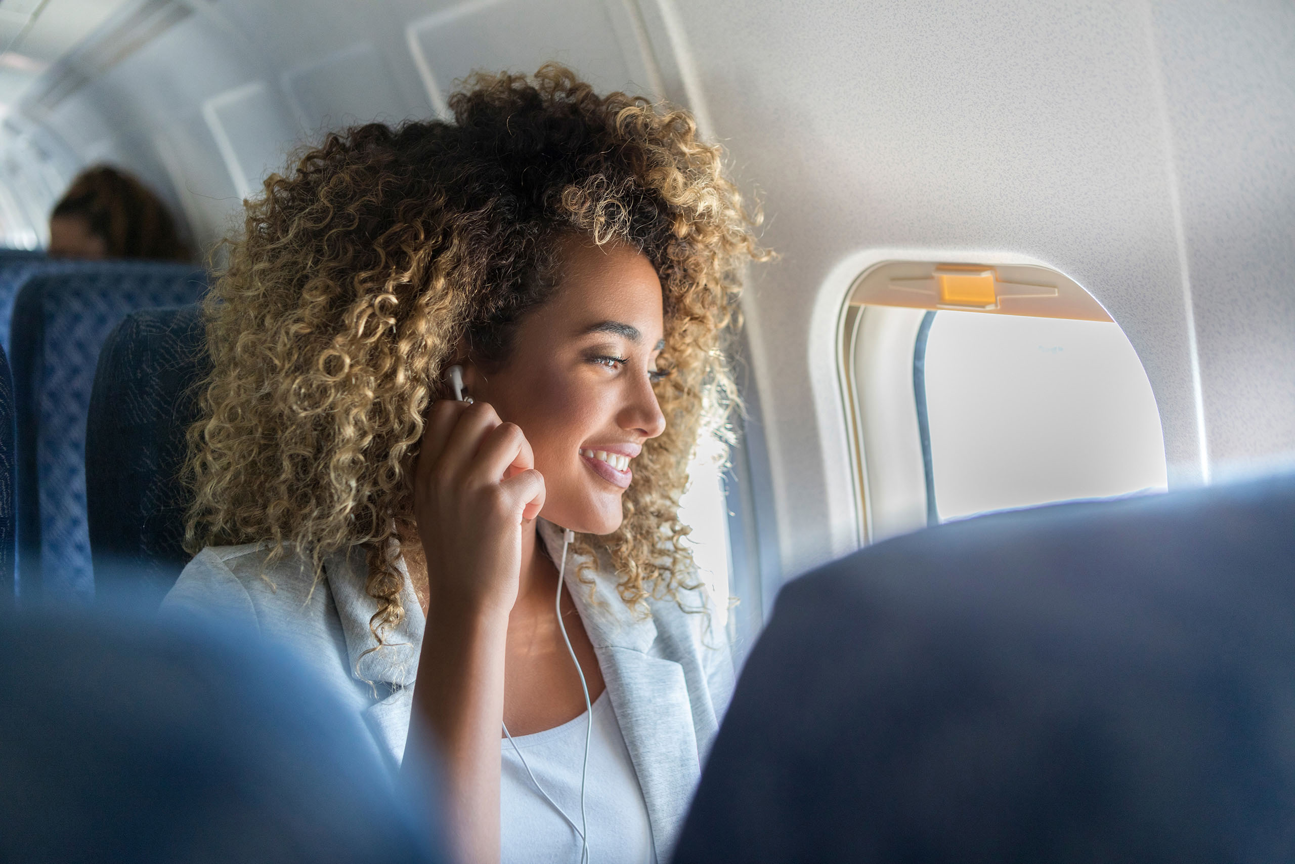 Frau mit Kopfhörern im Flugzeug