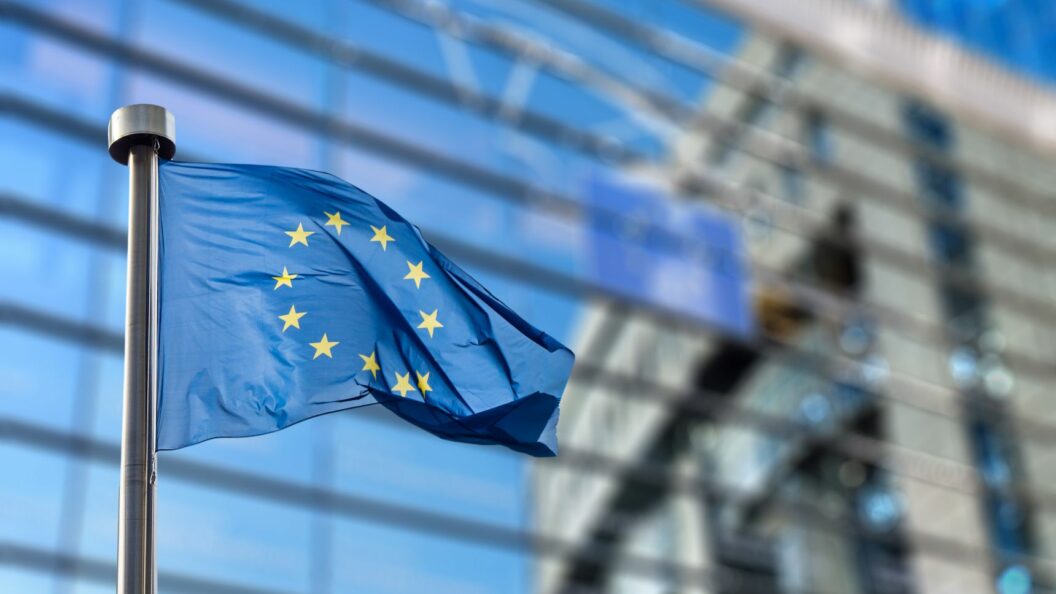 EU-Flagge vor Glasfassade, Einführung EU Entry/Exit System EES im Oktober 2025