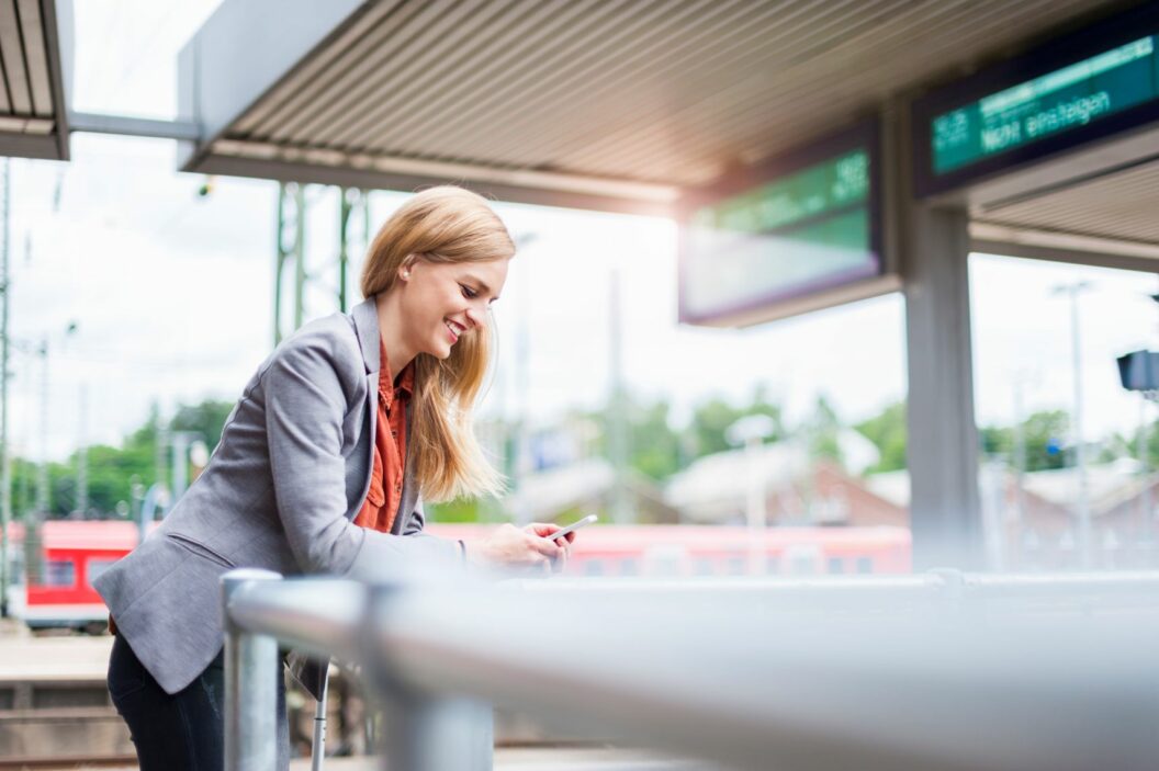 Junge Frau am Bahnhof. Symbolbild für Sparpreis Business der Deutschen Bahn